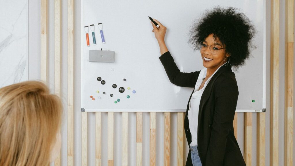 Personne expliquant au tableau quelque chose à une autre femme